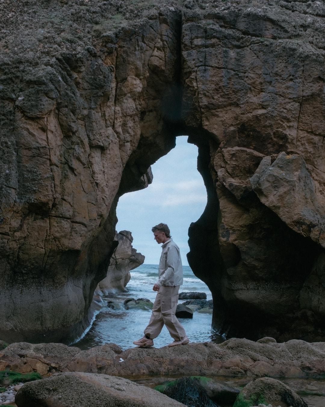 Person exploring the rugged coastline of Scotland wearing BLÆST