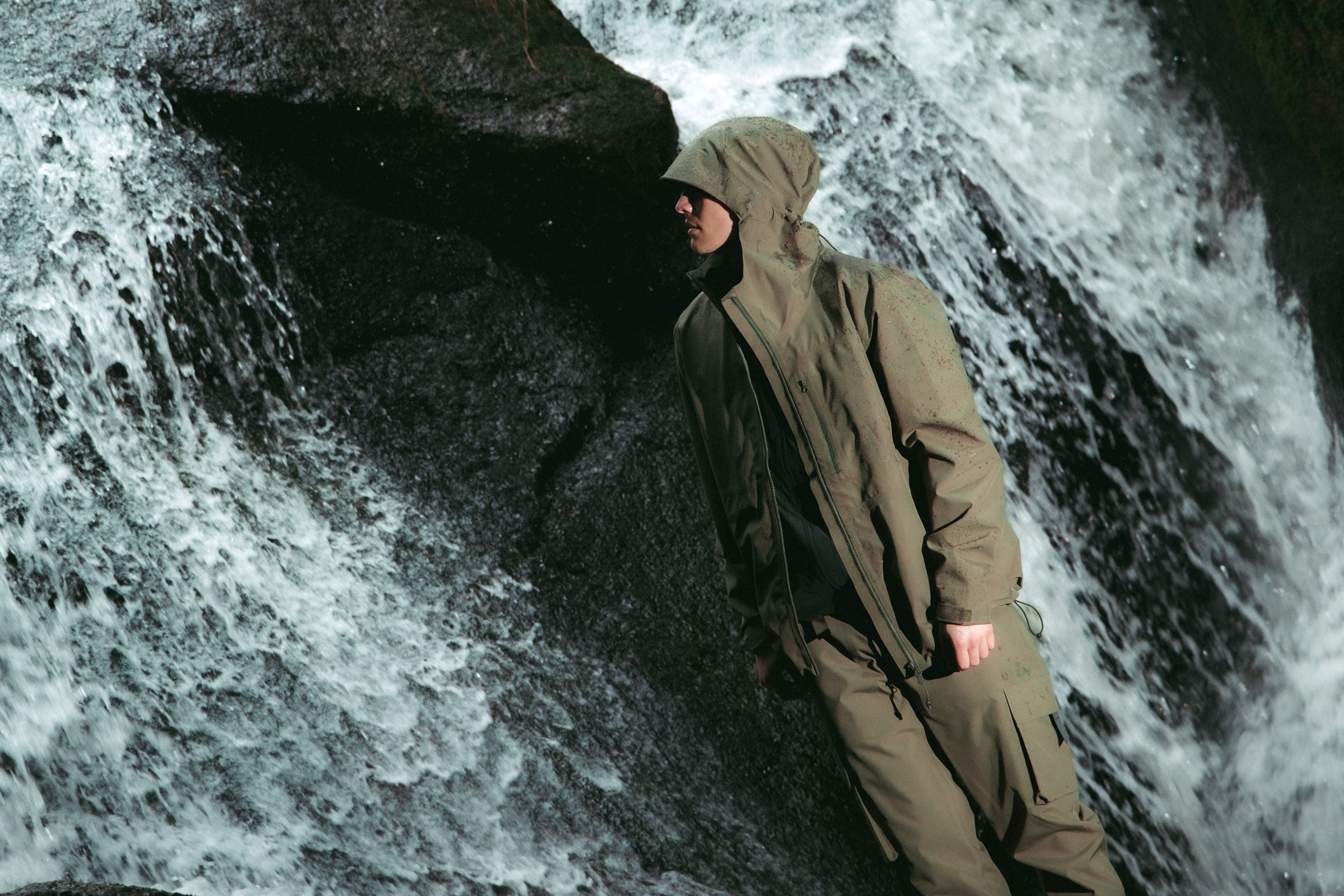 Man standing in front of a waterfall, wearing waterproof styles from BLÆST