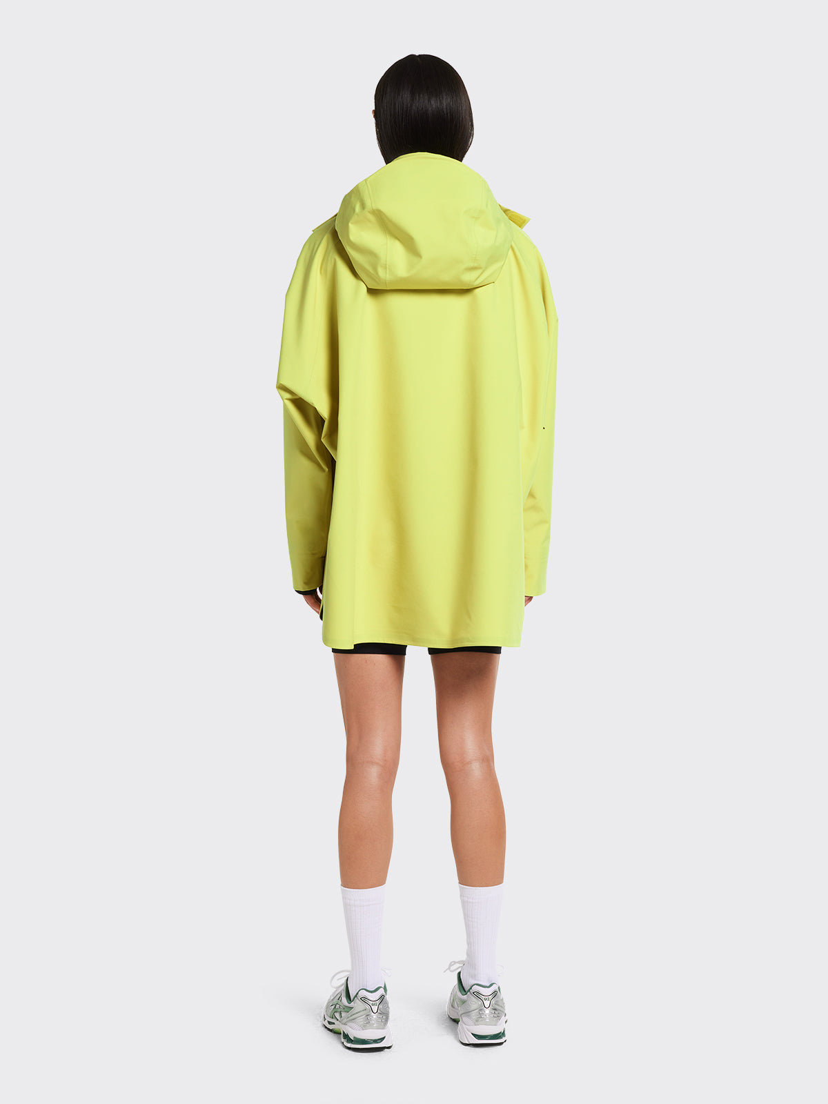 Woman in Voss poncho in the color Muted Lime from Blæst