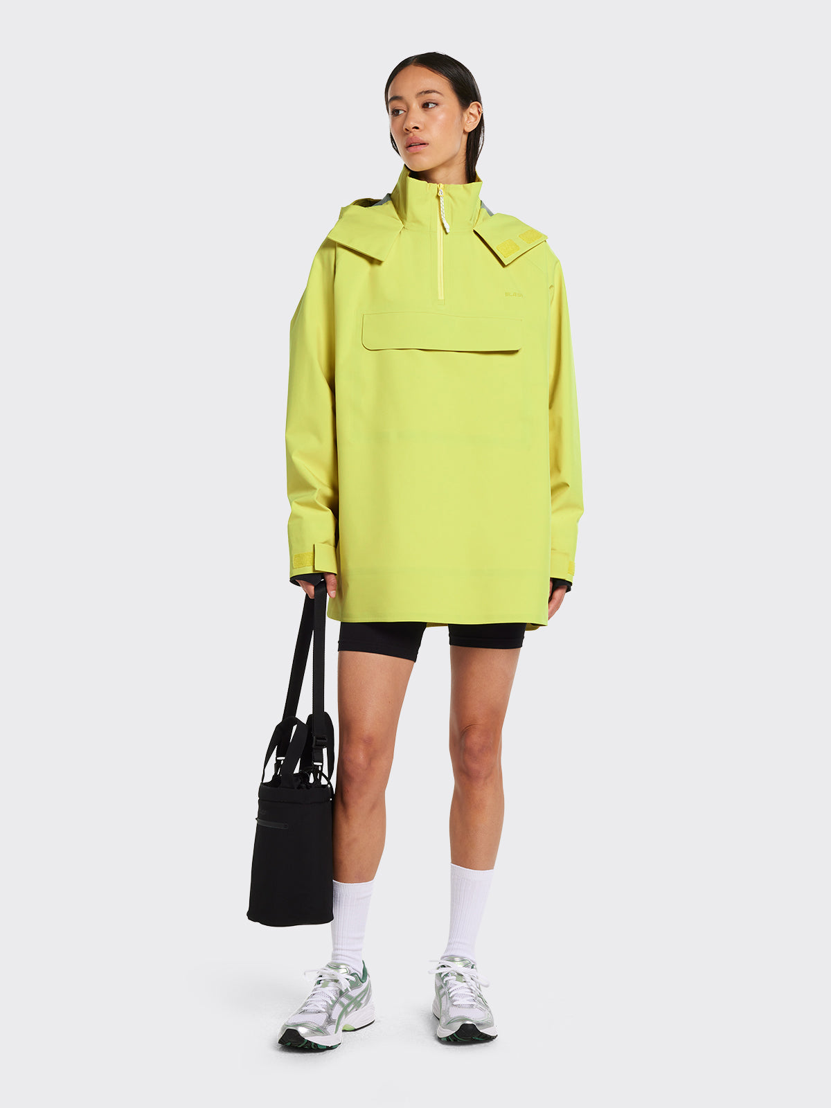 Woman in Voss poncho in the color Muted Lime from Blæst