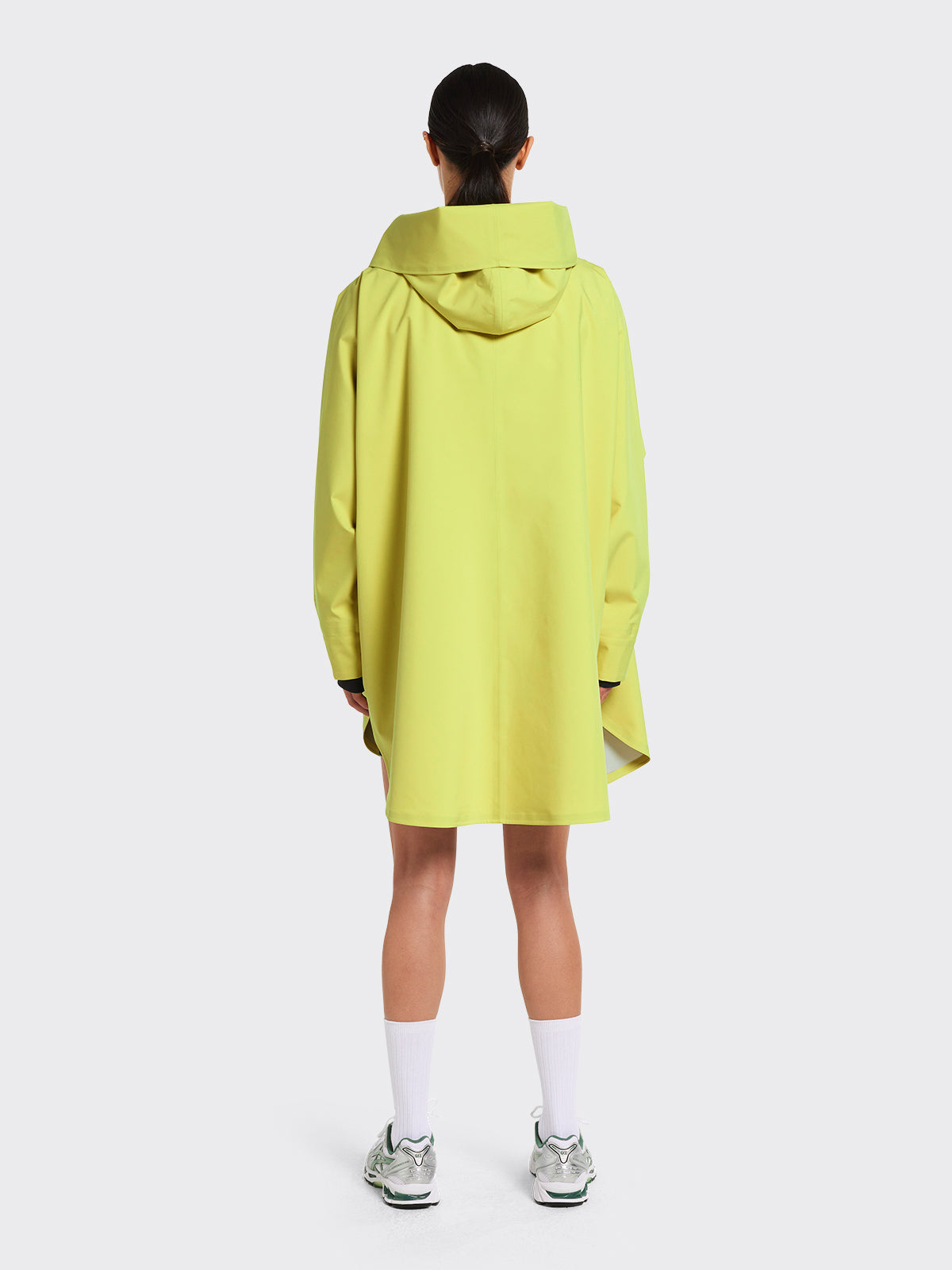 Woman dressed in Bergen poncho in the color Muted Lime from Blæst