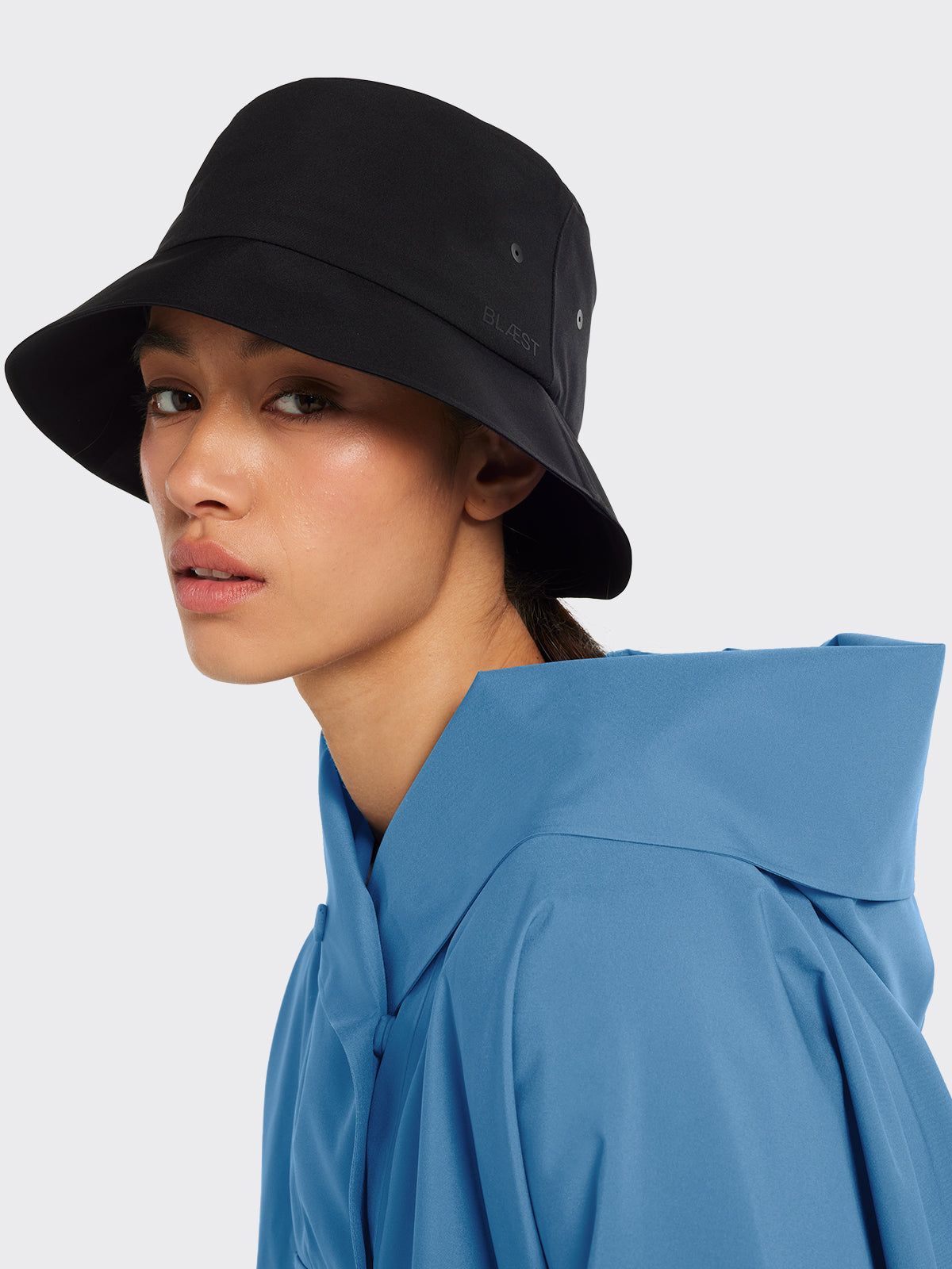 Woman wearing Øya bucket hat and Bergen poncho from Blæst