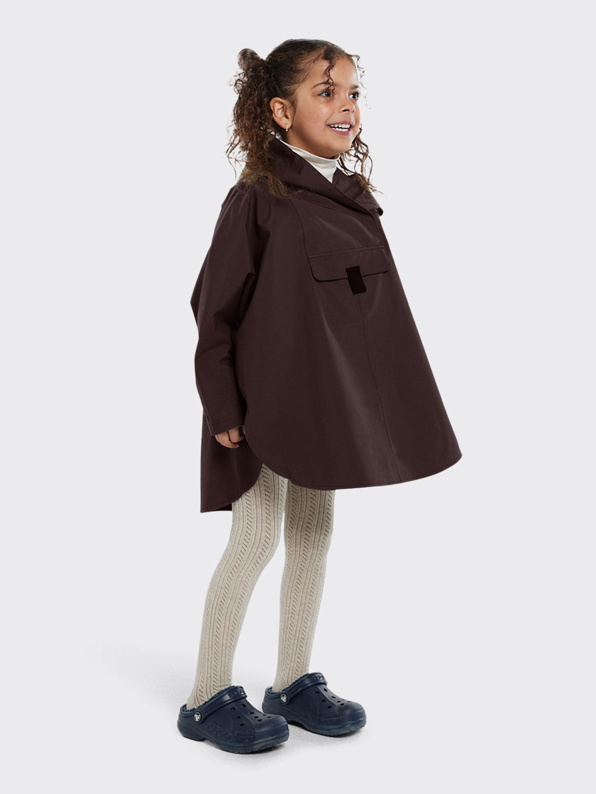 Girl dressed in Bergen mini poncho by Blæst in the color Java