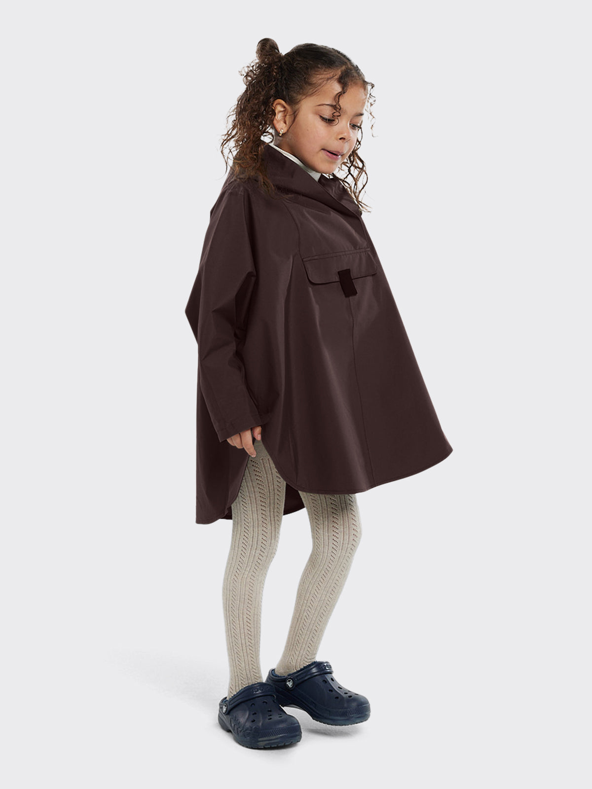 Girl dressed in Bergen mini poncho by Blæst in the color Java