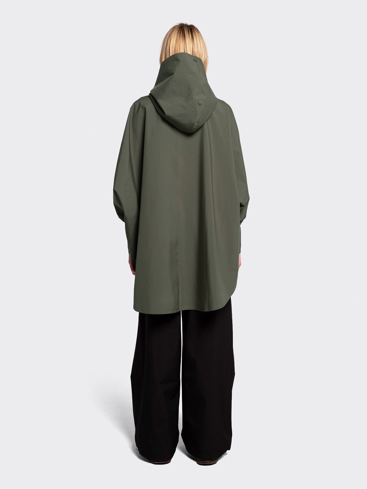 Woman dressed in Bergen poncho by Blæst in Dusty Green